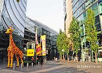 DU2016 DSC 5586-1429  Tegenover het 'dorpse' blok van okersteen en glas, aan de zuidzijde van de Potsdamer Platz, is een spectaculair gebouwenblok opgericht (arch.  Murphy/Jahn) van staal en glas, rondom een indrukwekkend atrium met een gigantische 'circustent' erboven op.