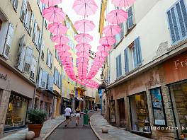 GRASSE_DSCF8385 Zeer charmant zijn de roze paraplus die boven de straat hangen om het zomerzonlicht uit de smalle straatjes te houden, als het schijnt.